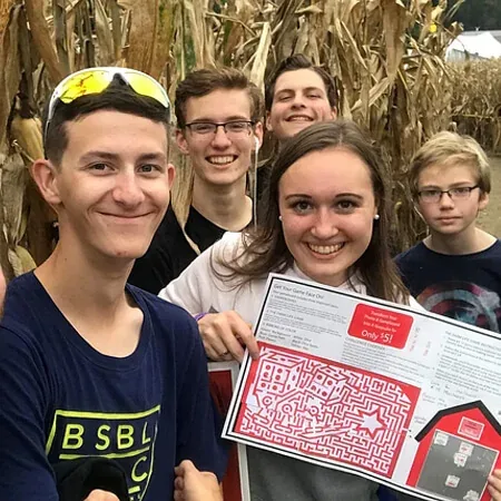 Visitors using a maze map at a path junction inside the corn at Cherry Crest Adventure Farm
