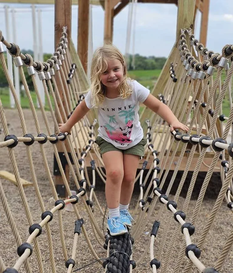 A child crossing a rope bridge at Howell’s Pumpkin Patch