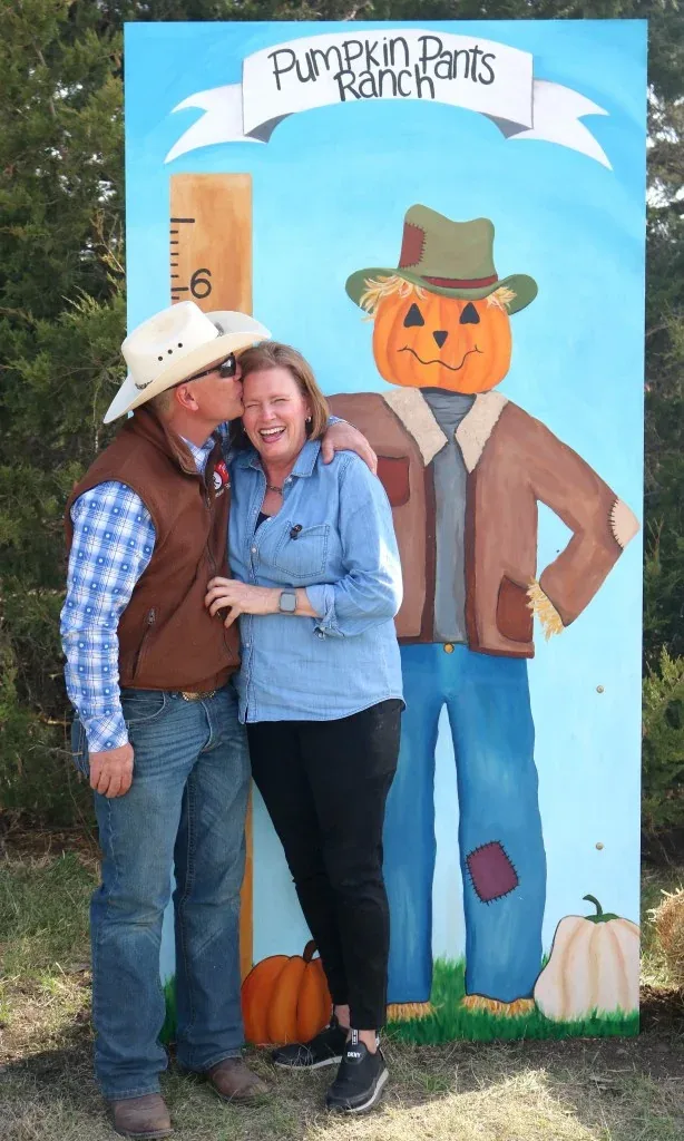 Visitors beside the Pumpkin Pants Ranch photo board