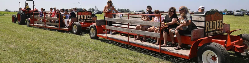 Visitors riding the open red tram at Rader Family Farms
